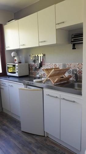 une cuisine blanche avec des armoires blanches et un évier dans l'établissement T2 proche gare avec WiFi parking, à Angers