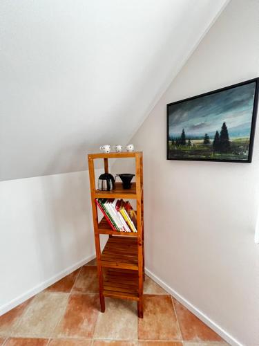 a book shelf in a room with a painting on the wall at Eifeleule in Hürtgenwald
