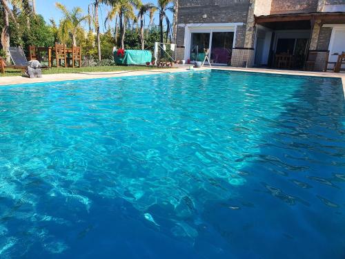 a swimming pool with blue water in front of a house at Appartement 33 de 3 chambres ensoleillé à 5 min de la plage El Jadida Piscine à 15km de l'appartement in El Jadida