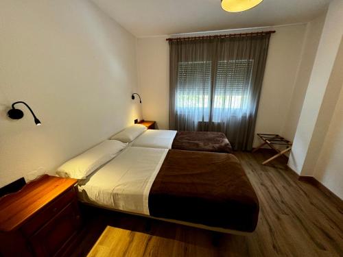 a bedroom with a large bed and a window at Apartamentos Turisticos Poblado in Arinsal