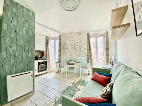 un salon avec un canapé et une cuisine dans l'établissement Nid douillet et lumineux, à Paris