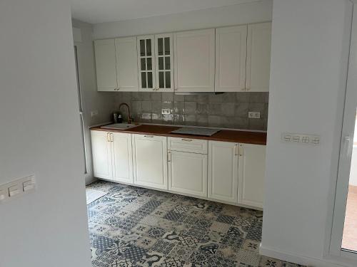 a kitchen with white cabinets and a tile floor at Casa Susana in La Azohía