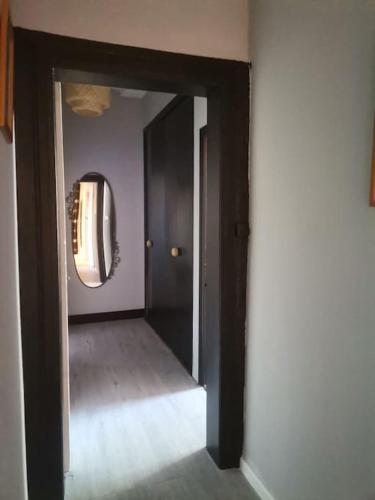 a hallway with a black door and a mirror at Madras in Sète