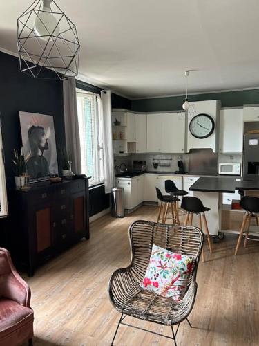 a living room with a chair and a kitchen at Madras in Sète