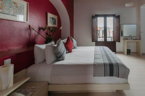 a bedroom with a large bed with red walls at La Catrina de Alcala in Oaxaca City