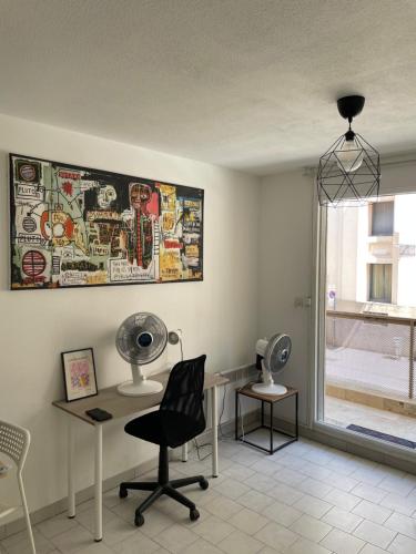 Cette chambre comprend un salon de coiffure avec une chaise et un ventilateur. dans l'établissement Très beau studio près du centre ville, à Nîmes