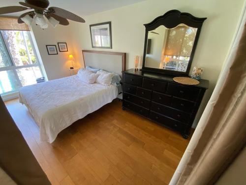 a bedroom with a bed and a dresser with a mirror at Northcoast Village ocean views in Oceanside