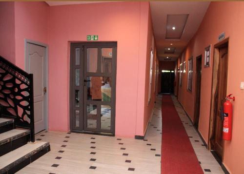 a corridor of a building with pink walls and a door at Ramat Luxury Hotel in Mangpontin