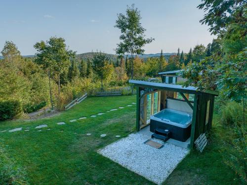 a small shed in the grass in a yard at Refuge Exitchalets Spa & View in Sainte-Lucie-de-Doncaster