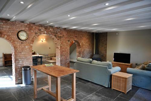 a living room with a couch and a table at The Cider House at Stathe Farm in Burrowbridge