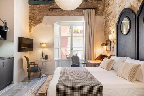 a bedroom with a large bed and a window at Art Suites by Casa del Santo in El Puerto de Santa María
