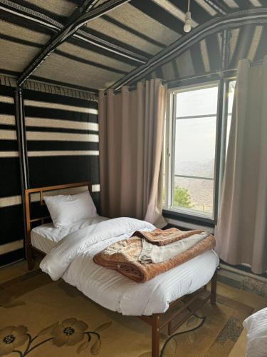 a bedroom with two beds and a window at Wild Dana Eco Lodge- Hotel-Eco-Camp in Dana