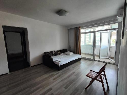 a bedroom with a bed and a large window at La Constanta Gara in Constanţa