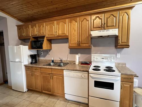 una cucina con elettrodomestici bianchi e mobili in legno di Saga Resort a Wasaga Beach