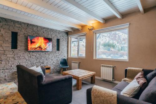 a living room with two couches and a fireplace at Ski Sur Apartments in San Carlos de Bariloche