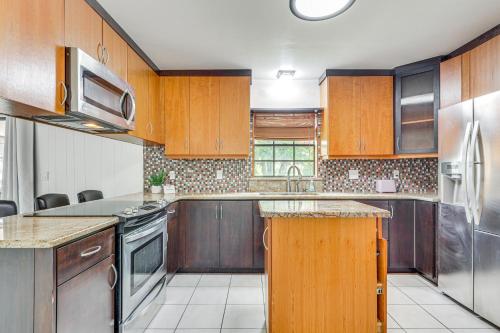a kitchen with wooden cabinets and stainless steel appliances at Modern Wimauma Family Home with Private Pool and Yard! in Sun City Center