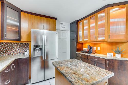 a kitchen with wooden cabinets and a stainless steel refrigerator at Modern Wimauma Family Home with Private Pool and Yard! in Sun City Center