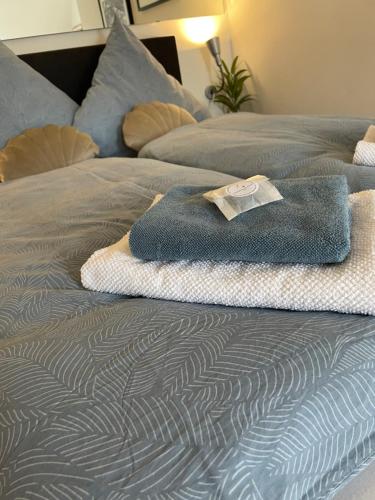 two beds with towels sitting on top of them at Strandliebe - Beach Apartment mit Meerblick in Harrislee