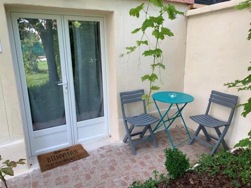 2 chaises et une table devant une porte dans l'établissement 'StudioCDG fr' Cerisier, Studio proche near CDG Roissy airport, Parc Expositions, Stade de France, Arena, Disney, Asterix, à Villepinte