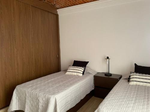 a bedroom with two twin beds and a night stand at hRuiz Lodgments in Lagos de Moreno