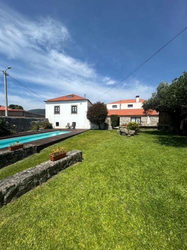 a yard with a house and a swimming pool at Casa do Sorrio - Slow Down, Live Now in Viana do Castelo