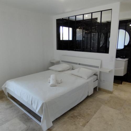 - une chambre blanche avec un lit blanc et une fenêtre dans l'établissement Mas en Provence, au Thor