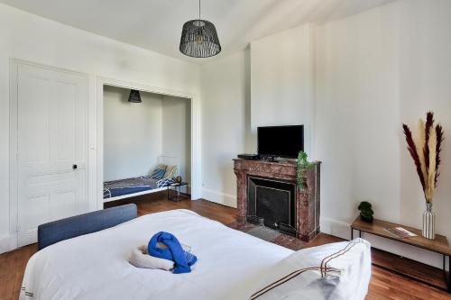 - un salon avec un lit et une cheminée dans l'établissement L'Oasis Urbaine - Spacieux et élégant pour 5 pers, à Saint-Fons