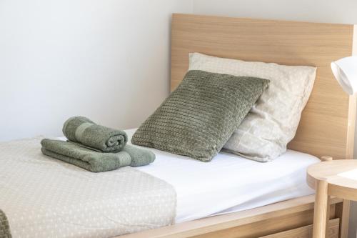 a bed with green and white pillows on it at Casa Blanca in El Vendrell