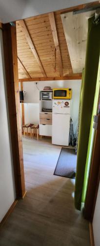 a kitchen with a stove and a refrigerator at Chalet calme in Saint-Léger-les-Mélèzes
