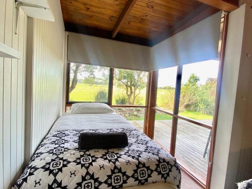 a bedroom with a bed and a large window at Prom Coast Oasis - Sandy Point in Sandy Point
