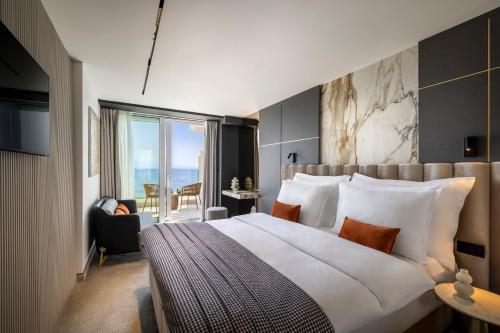 a hotel room with a large bed and a balcony at Grand Hotel Adriatic in Opatija