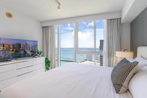a bedroom with a large white bed and a large window at ICON Brickell Miami- 2 bedroom Condo with City and water views! in Miami