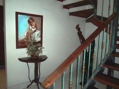 a staircase with a painting of a woman on the wall at Hotel Discovery in Santo Domingo