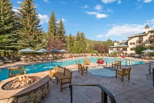 a swimming pool with chairs and a fire pit at The Charter at Beaver Creek E030 in Beaver Creek