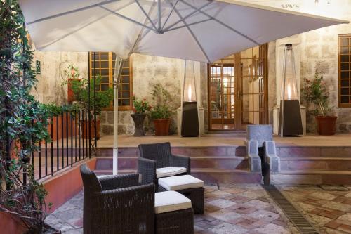 a patio with chairs and an umbrella at Hotel Casona Solar in Arequipa