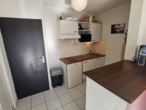 une petite cuisine avec un évier et un réfrigérateur dans l'établissement T2 centre ville, à Périgueux