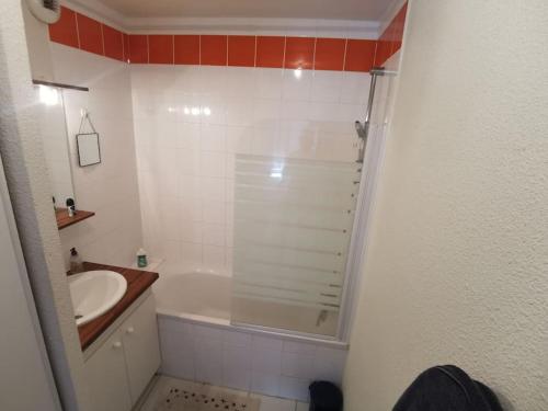 une salle de bain blanche avec un lavabo et une douche dans l'établissement T2 centre ville, à Périgueux