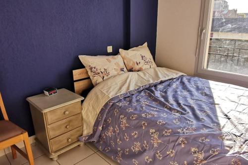 - une chambre avec un lit, une table de chevet et une fenêtre dans l'établissement T2 centre ville, à Périgueux