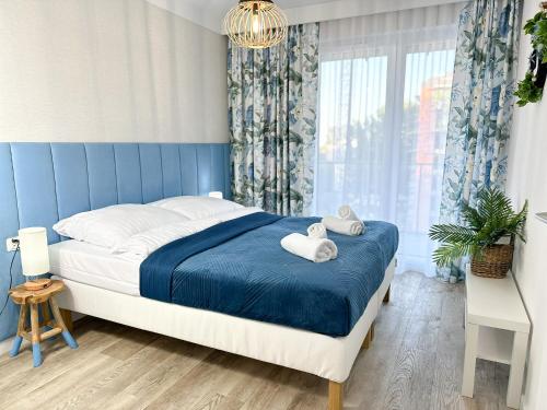 a bedroom with a bed with two towels on it at Apartamenty Coastal Comfort Kołobrzeg in Kołobrzeg