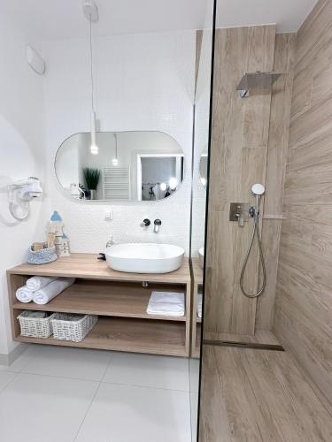 a bathroom with a sink and a mirror at Apartamenty Coastal Comfort Kołobrzeg in Kołobrzeg