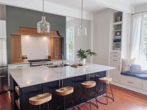 a kitchen with a large island with stools in it at Guesthouse on Girod in Mandeville