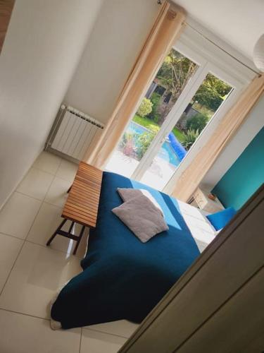 une chambre avec un lit bleu et une fenêtre dans l'établissement tranquillité et bien être, à Chauconin