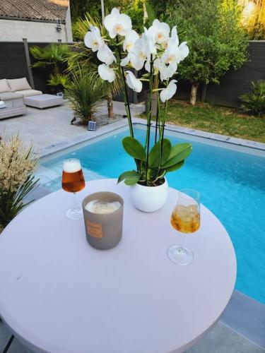 une table blanche avec des fleurs dessus à côté d'une piscine dans l'établissement tranquillité et bien être, à Chauconin