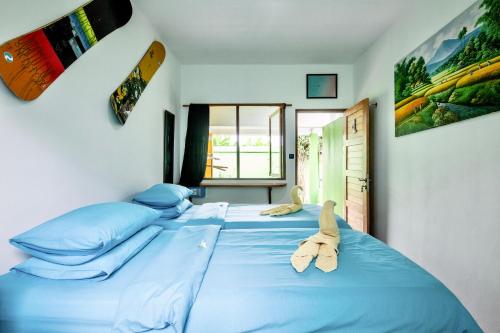 a bedroom with two large beds with blue sheets at Blue Coco in Keramas
