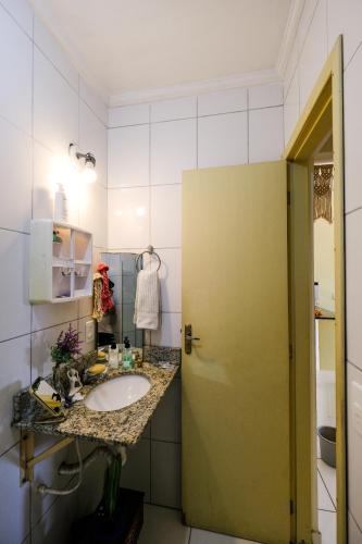 a bathroom with a sink and a green door at Apt 5 min da praia andando in Bertioga