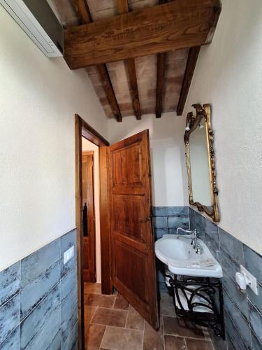 a bathroom with a sink and a wooden door at Terre di Cornossa in Marta
