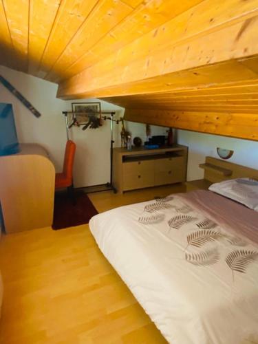 un lit dans une chambre avec un plafond en bois dans l'établissement Chez Philippe, à Saujon