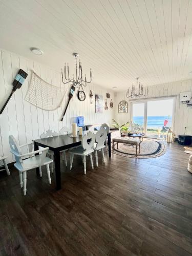 a dining room with a table and chairs and the ocean at Curiñanco Casa Playa in Curiñanco