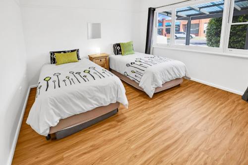 ein Schlafzimmer mit zwei Betten und einem Fenster in der Unterkunft Camellia Cottage on Church in Lakes Entrance