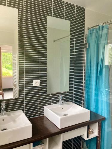 une salle de bain avec deux lavabos et un miroir dans l'établissement Ty Boiss', à Sainte-Marine